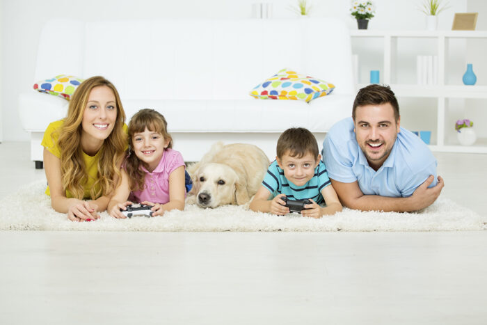 Cheerful Family on Carpet with Dog
